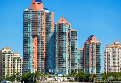 Aventura luxury real estate with waterfront high-rise condos, palm trees, and South Florida skyline views.