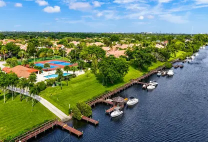 Bramalea Boca Raton waterfront real estate view with canal docks, boats, tropical green space, and private neighborhood amenities.