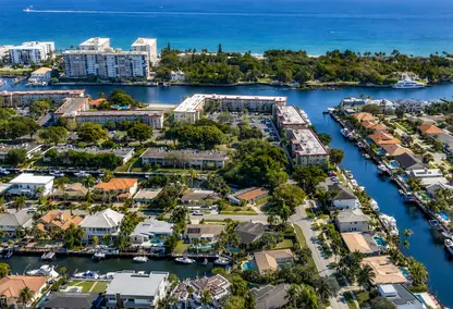 Aerial view of luxury waterfront homes in Lighthouse Point, Florida, featuring deepwater canals, private docks, ocean access, Coral Key Villas real estate.