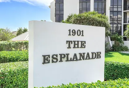 Esplanade Condominiums in Boca Raton, FL with entrance sign, tropical landscaping, and near-beach condo living.