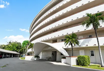 Hillsboro Cove Condominium in Deerfield Beach, South Florida featuring curved architecture, palm trees, and coastal condo living.