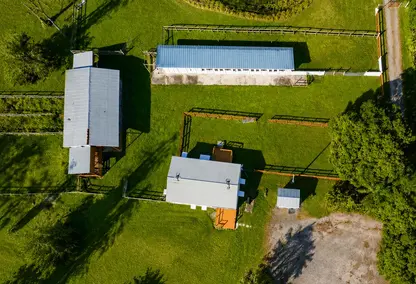 Loxahatchee Groves luxury real estate aerial with barns, fenced paddocks, green acreage, and rural South Florida equestrian lifestyle.