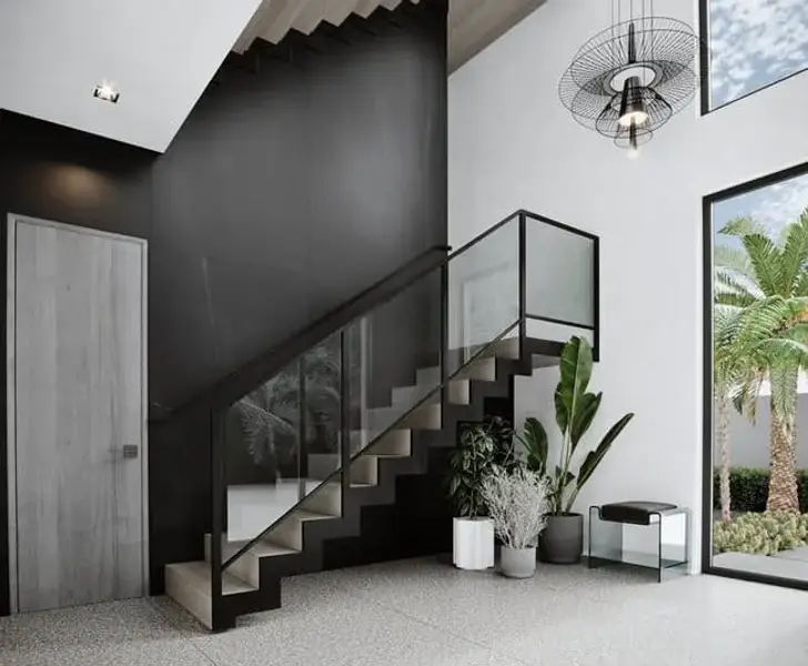 Glass staircase with dark railing features and high ceilings at 10Palms, Delray Beach.