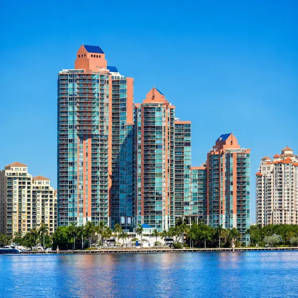 Aventura luxury real estate with waterfront high-rise condos, palm trees, and South Florida skyline views.