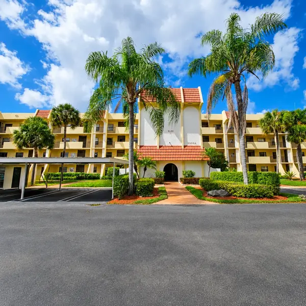 Boca Barwood condominium building in Boca Raton, FL with palm trees, tropical landscaping, and South Florida residential community.