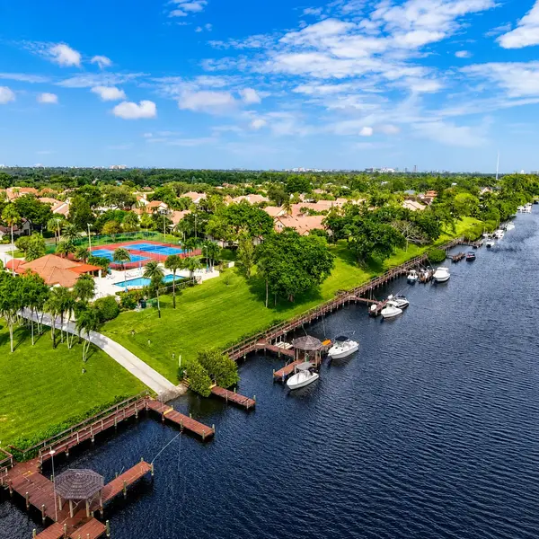 Bramalea Boca Raton waterfront real estate view with canal docks, boats, tropical green space, and private neighborhood amenities.
