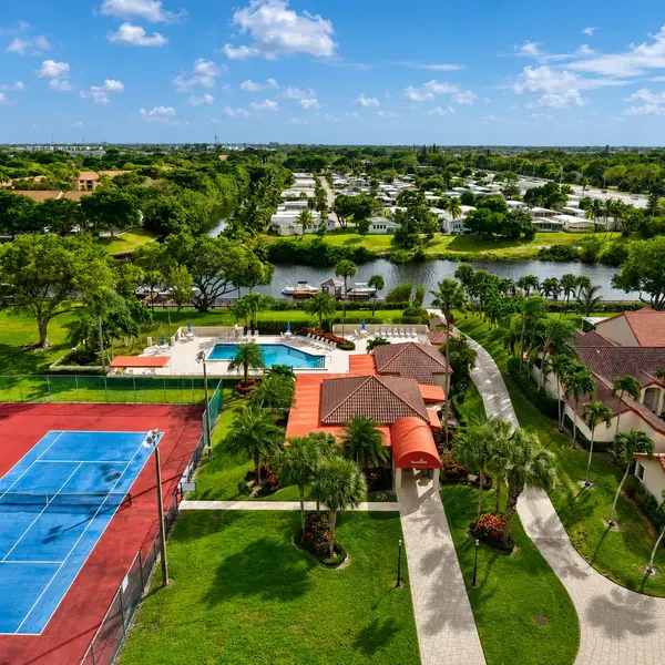 Bramalea neighborhood in Boca Raton with clubhouse, tennis courts, pool, canal views, palm trees, and South Florida real estate appeal.