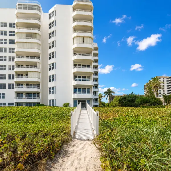 Clarendon Condo in Highland Beach FL with private beach walkway, oceanfront setting, tropical dunes, and luxury real estate appeal.