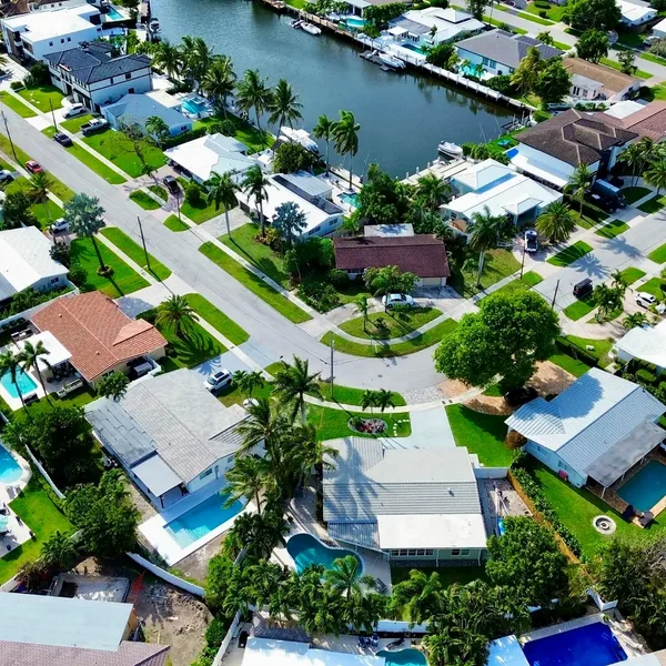 Aerial view of Lighthouse Point waterfront homes with private pools, canal-front lots, boat docks, and South Florida coastal real estate.
