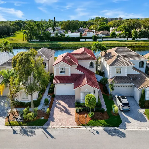 Costa Brava at Boca Pointe luxury home in Boca Raton with canal views, golf course backdrop, and tropical landscaping.