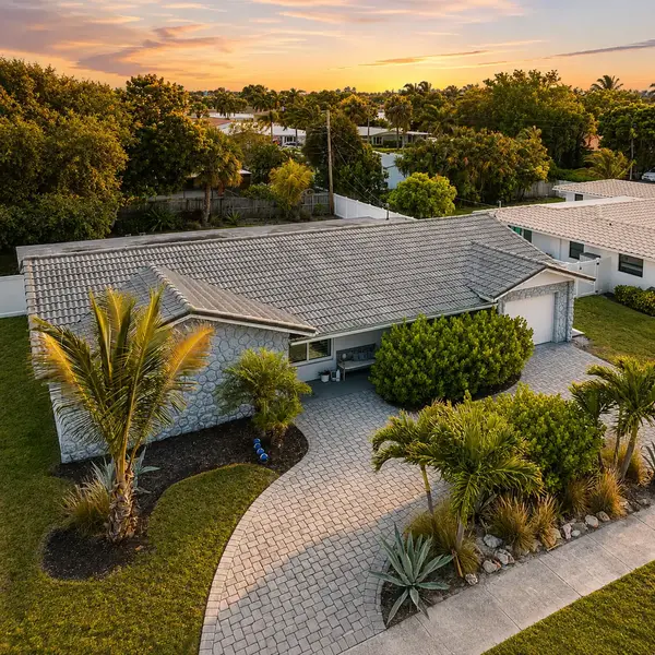 Country Club Village Boca Raton home with tropical landscaping, paver driveway, and upscale South Florida curb appeal.