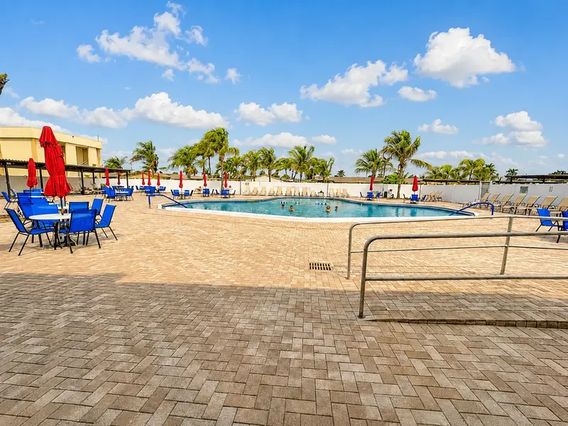 Crosley West Palm Beach community pool with lounge seating, tropical palms, and resort-style South Florida amenities.