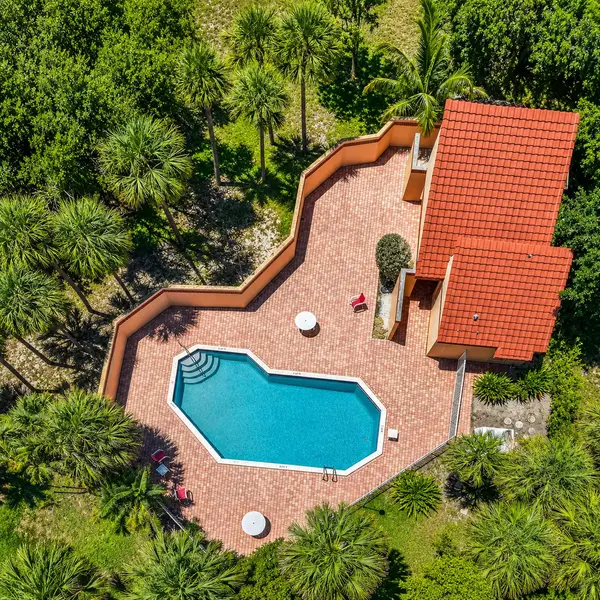 Estoville Boca Raton private pool home with tropical palms, spacious patio, and upscale South Florida outdoor living.