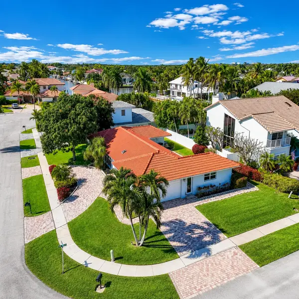 Estoville Boca Raton luxury home aerial with red tile roof, tropical landscaping, and waterfront neighborhood views.