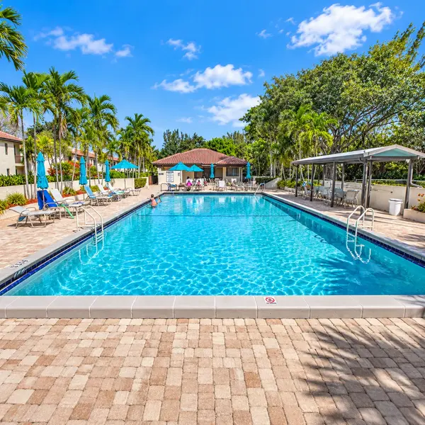 Glades of Boca Lago Boca Raton resort-style pool with lounge chairs, palms, and active adult 55+ amenities.