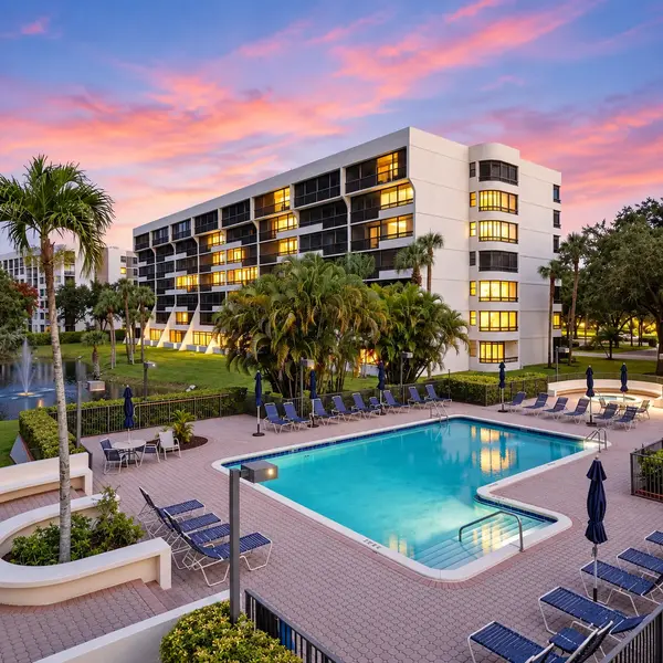 The Glens Boca Raton 55+ condo pool with tropical landscaping, sunset lighting, and resort-style amenities.