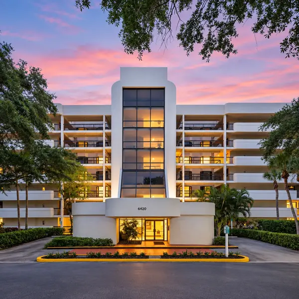 The Glens 55+ condo building in Boca Raton with modern entrance, tropical trees, and luxury South Florida appeal.