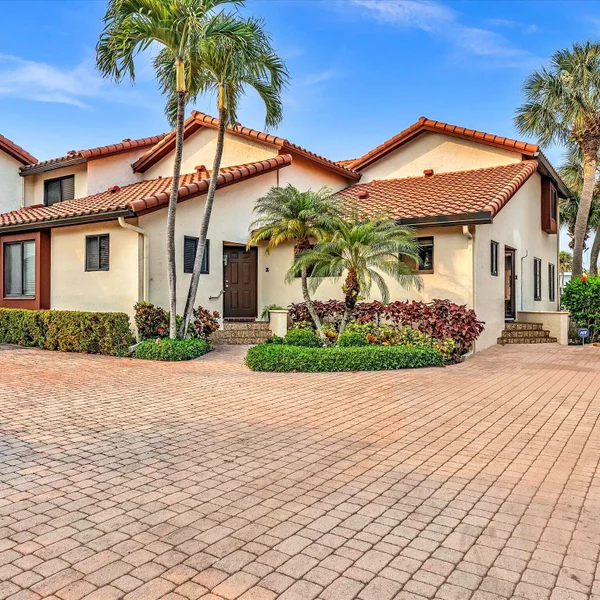 Villa del Alto (Highland Beach Isles) Townhomes in Highland Beach, FL featuring Mediterranean-style exterior, palm trees.