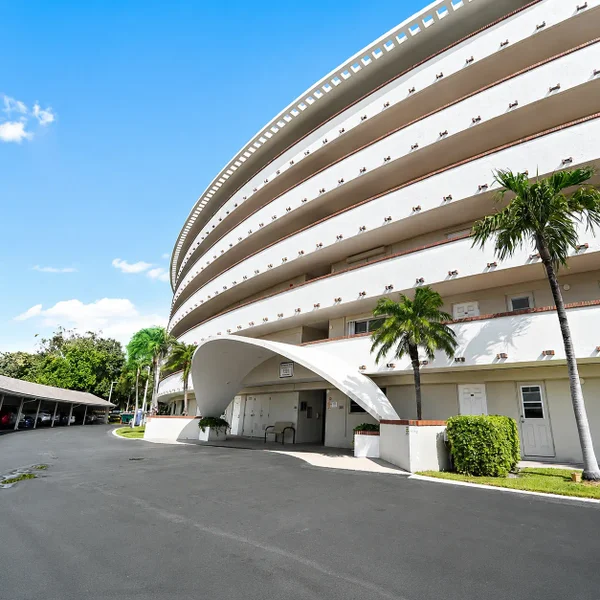 Hillsboro Cove Condominium in Deerfield Beach, South Florida featuring curved architecture, palm trees, and coastal condo living.