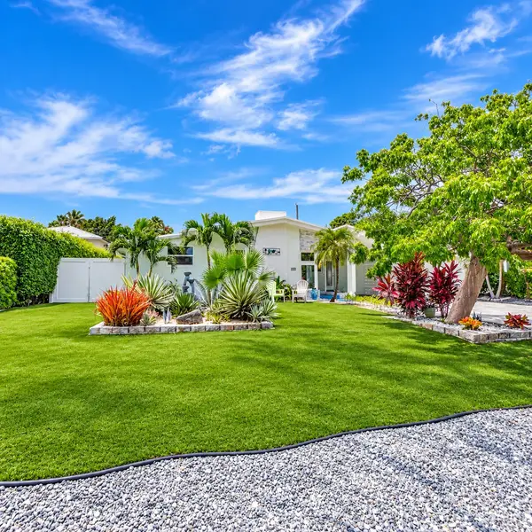 Lake Wyman Shores Boca Raton home with lush tropical landscaping, modern curb appeal, and sunny coastal setting.