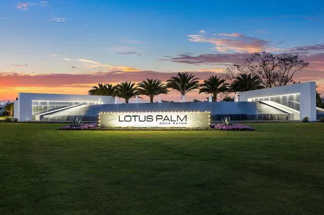 Streeview of the Lotus Palm entry sign with lighting and waterfall detail at night.