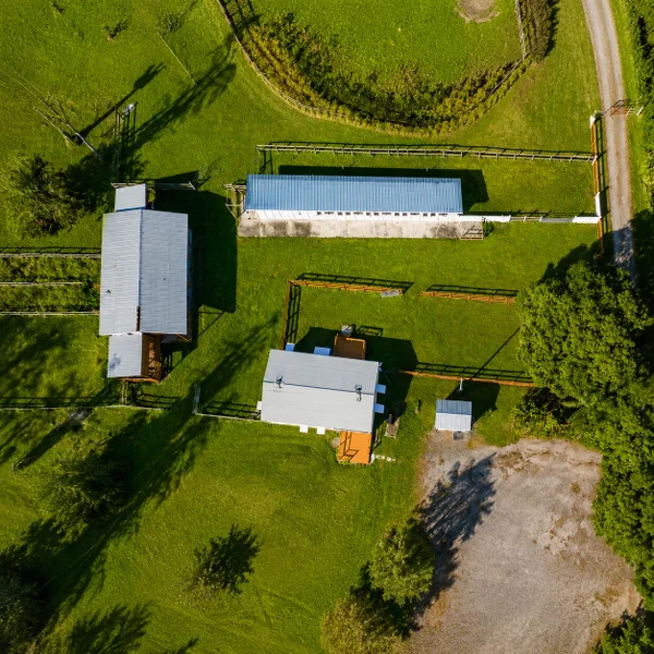 Loxahatchee Groves luxury real estate aerial with barns, fenced paddocks, green acreage, and rural South Florida equestrian lifestyle.