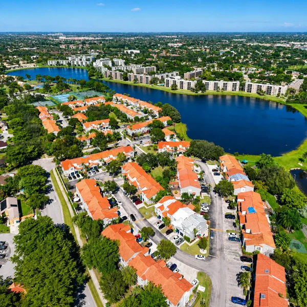 Miramar City aerial view with lakefront townhomes, orange tile roofs, green space, and South Florida residential living.