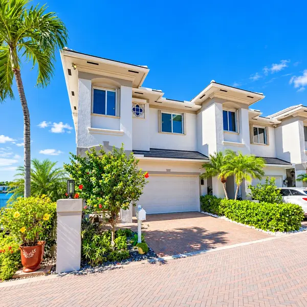 Lake Wyman Estates Boca Raton waterfront townhome with tropical landscaping and luxury curb appeal.