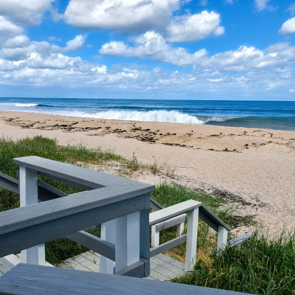 Ocean Ridge Florida luxury real estate beach view with coastal walkway, sandy shoreline, ocean waves, and upscale seaside lifestyle.
