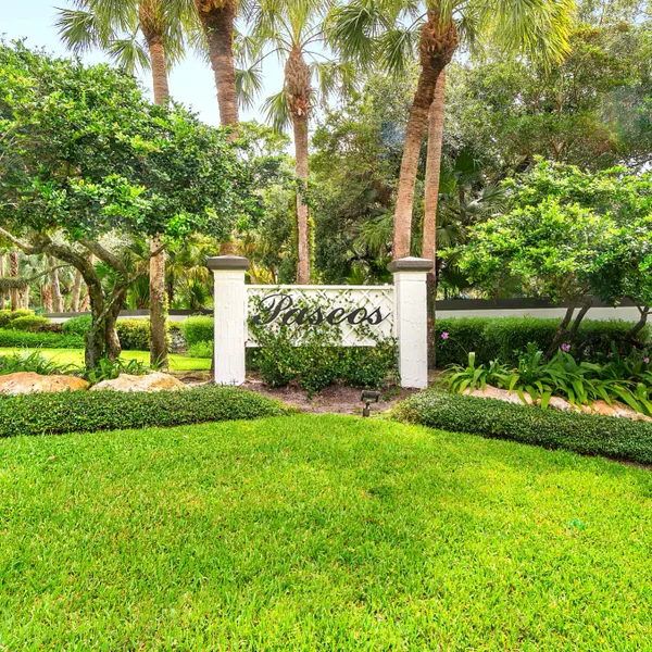 Paseos gated community entrance in Boca Raton, South Florida with tropical landscaping, palm trees, and manicured green space.