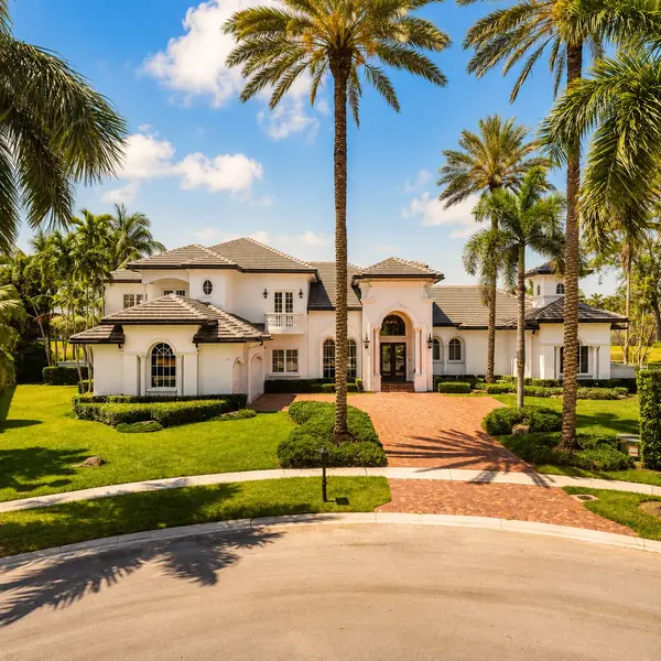 Plantation South Florida luxury home with tropical landscaping, palm trees, and upscale residential curb appeal.