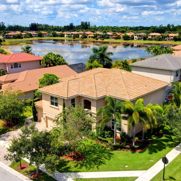 Royal Palm Beach luxury real estate aerial with lakefront homes, manicured lawns, tropical landscaping, and upscale South Florida community views.