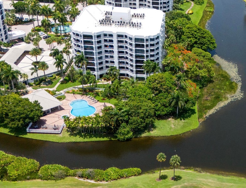 Aerial view of Fairway Point Condos in Boca West Country Club, Boca Raton, featuring a condo building surrounded by ponds, and greenery