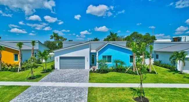 Front view of a single-family rental home at Yamato Villas in Boca Raton with greenery set against blue skies.