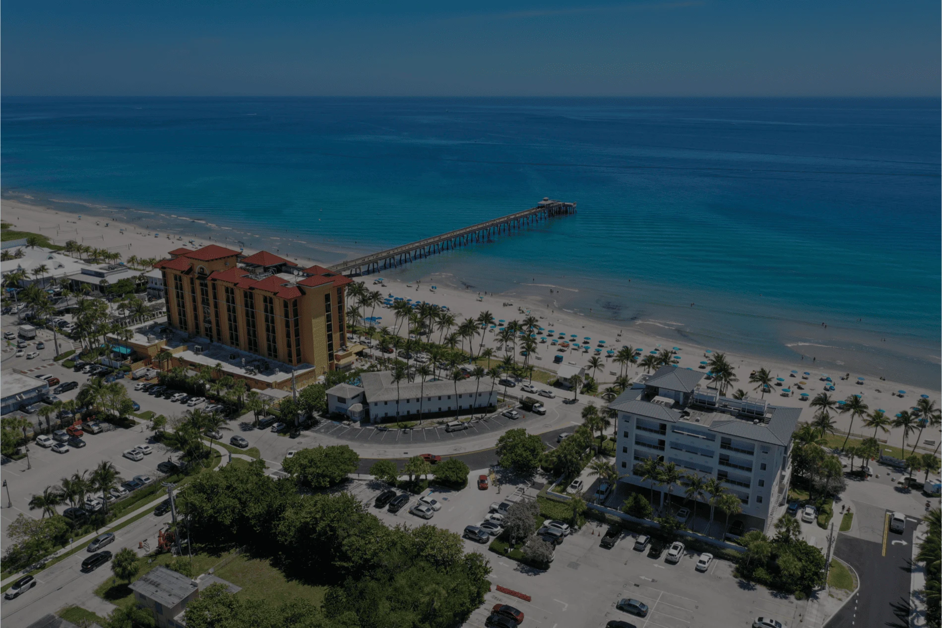 Multi-story condominium buildings shown along the Atlantic Coast in Deerfield Beach, FL.