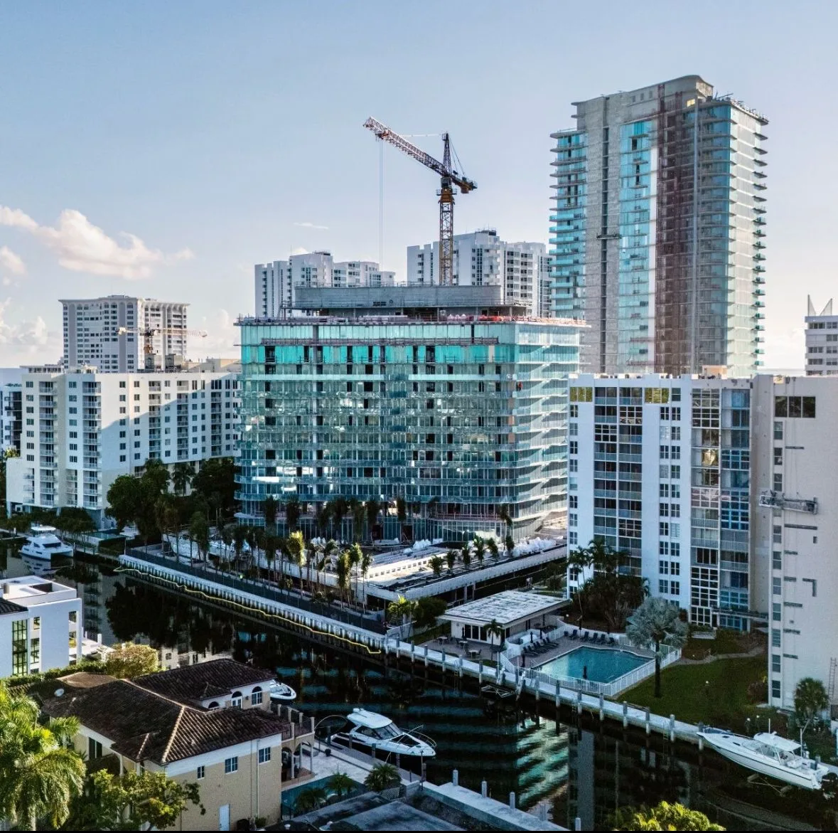 Close-up of the Ritz-Carlton Residences Pompano Beach Intracoastal tower with completed glass panels and rooftop work.