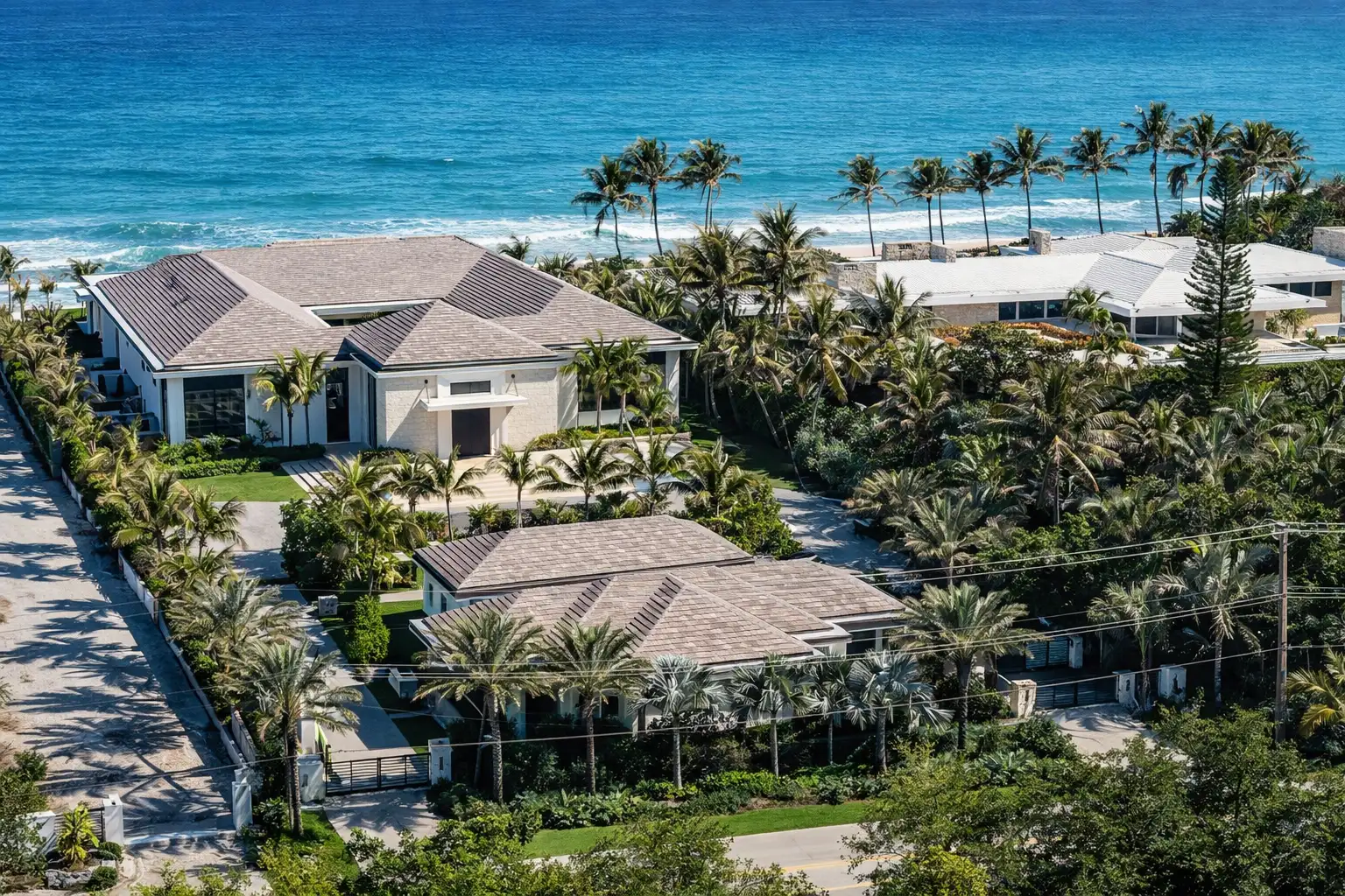 Hyperrealistic aerial of a Manalapan oceanfront estate with modern single-story homes, lush landscaping, and turquoise shoreline
