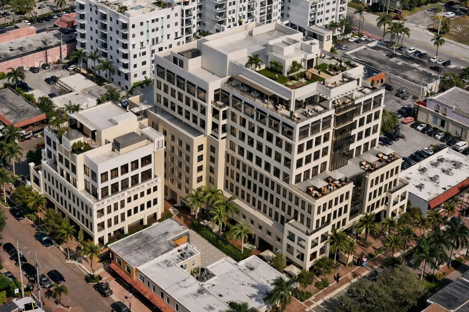 Aerial view of the Aletto mixed-use development in downtown Boca Raton with rooftop terraces, palm trees, and surrounding city blocks.