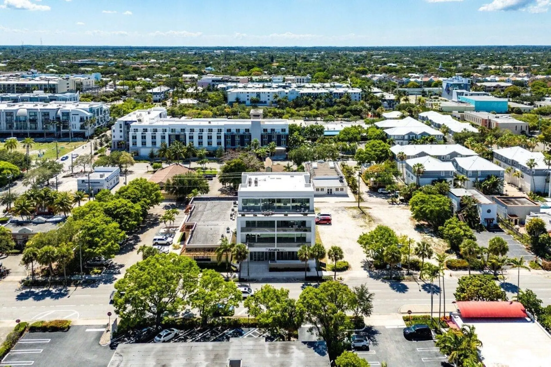 Aerial view of Aria Delray Beach, a boutique condo building surrounded by residential homes, trees, and modern developments.