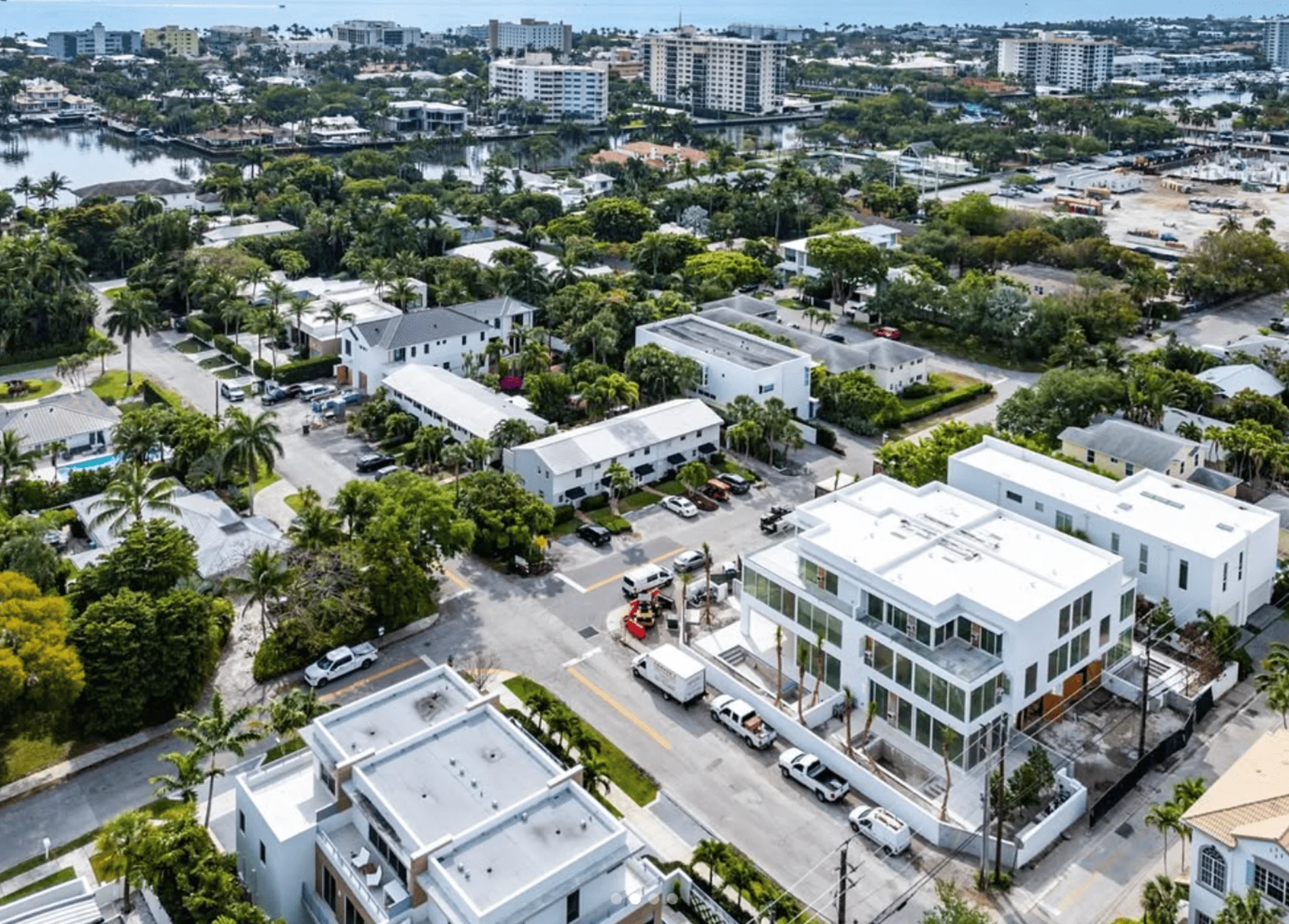 Aerial view of Asea Delray Beach, featuring modern white buildings, palm-lined streets, and nearby waterfront condos.