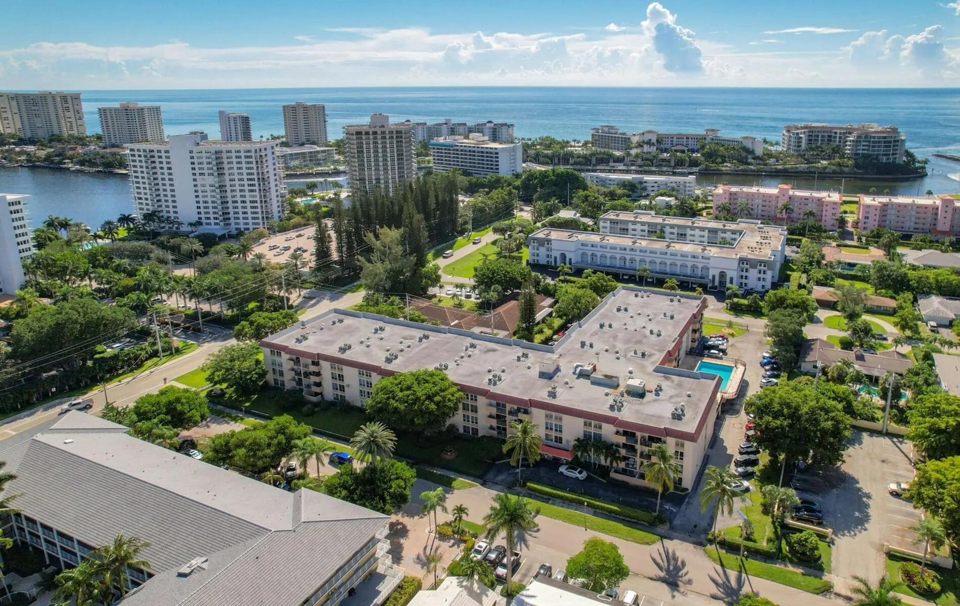 Aerial view of Boca View condominiums in Boca Raton with green trees and the Intracoastal waterway in the distance.