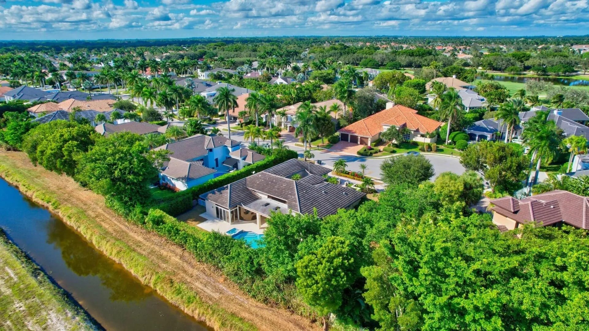 Aerial view of large homes in Devon place in Woodfield Country Club surrounded by trees green and views of the canal.