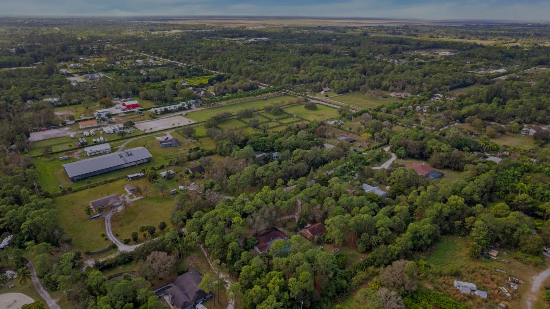 Aerial view of Loxahatchee Groves, Florida with rural estates, equestrian properties, tree-lined acreage, and South Florida landscape.